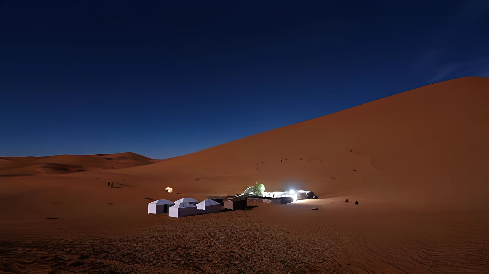 Overnight camping in the desert with tents under starry sky